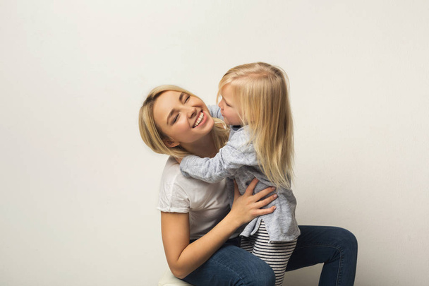 Mère et fille heureuses embrassant au studio
 - Photo, image