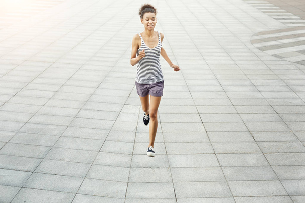 Young woman jogging in city copy space - Photo, Image