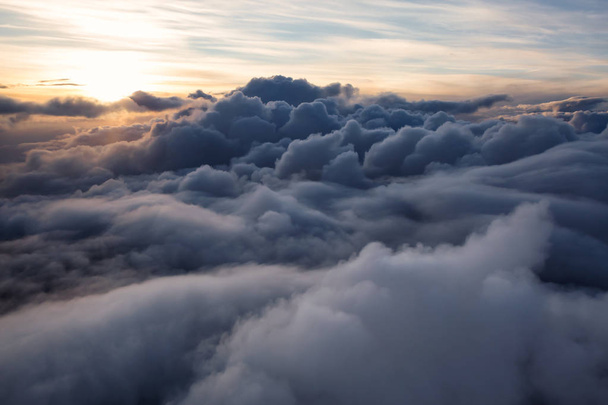 Όμορφη και εντυπωσιακή Αεροφωτογραφία από τα αυξομειούμενα σύννεφα κατά τη διάρκεια ένα πολύχρωμο ηλιοβασίλεμα. Λαμβάνονται κοντά Vancouver, British Columbia, Καναδάς. - Φωτογραφία, εικόνα