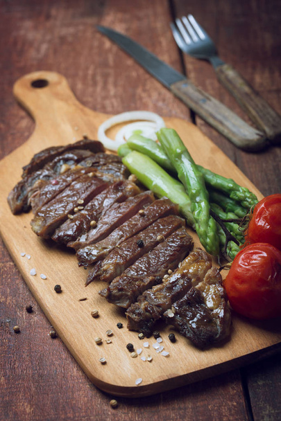 Grilled beef steak on a wooden rustic background - Photo, image