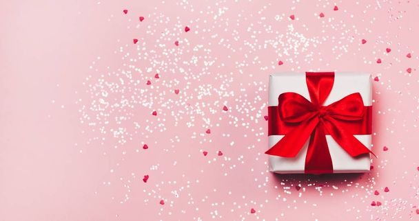 Gift box with sparkling glitter on pink background. Romantic st. Valentine's day concept of greetings. place for your text. Top view, flat lay - Φωτογραφία, εικόνα