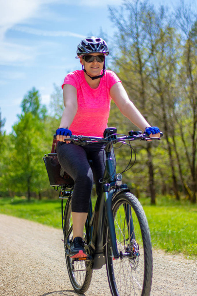 自転車に若い女性の日を楽しむ - 写真・画像