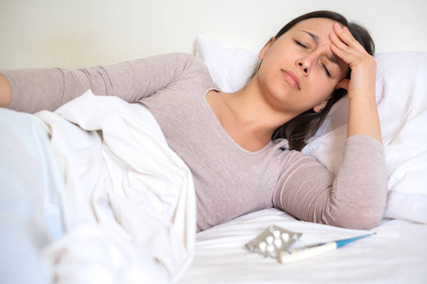 Πορτρέτο πρόσωπο λυπημένος και άρρωστος γυναίκα ξαπλωμένη στο κρεβάτι της - Φωτογραφία, εικόνα