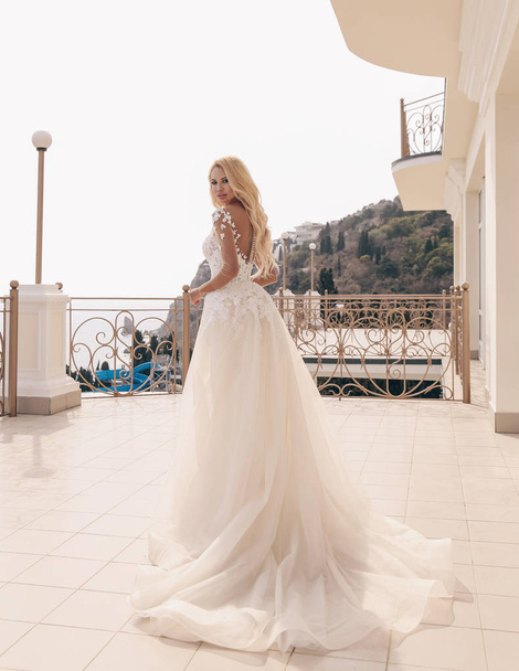 fashion outdoor photo of beautiful sensual woman with blond hair in luxurious wedding dress and accessories - 写真・画像