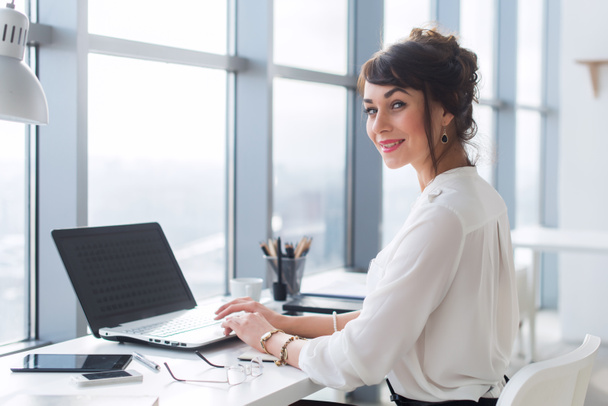 жінка працює з ноутбуком на столі в офісі
 - Фото, зображення