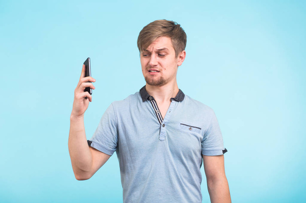 Красивый мужчина с усталым и раздраженным взглядом отнимает телефон от ее уха, пытаясь отойти от жалоб одержимых и раздражающих людей
 - Фото, изображение