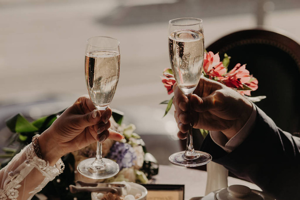 Close up image of glasses of champagne or wine, clink glasses, celebrate together their wedding day, hve festive event. People, dating and celebration concept - Fotoğraf, Görsel