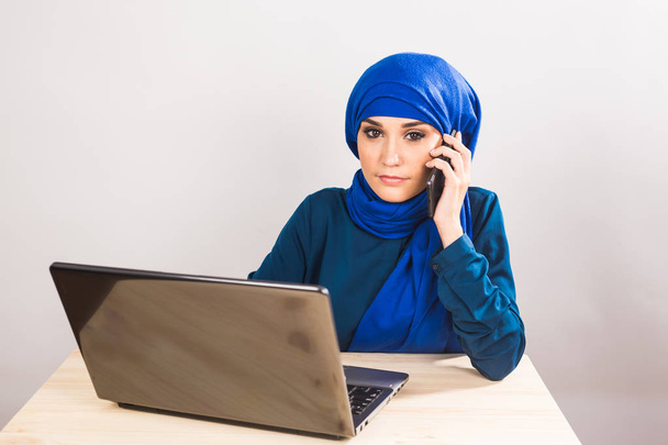 schöne junge arabische Frau spricht auf Handy auf weißem Hintergrund - Foto, Bild