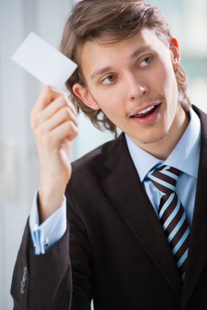 Business man holding a blank business card indoors at his office - Photo, Image