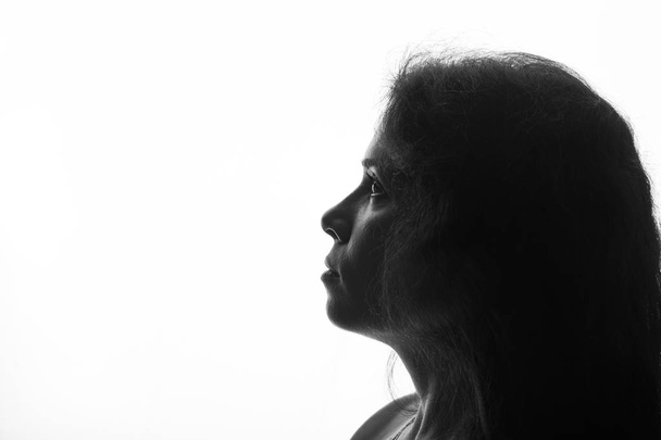 Retrato de una mujer joven mirando hacia arriba silueta horizontal sobre fondo blanco
 - Foto, Imagen