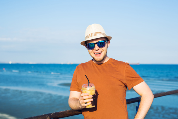 homme avec café frappe près de la mer se sentir libre profiter des vacances en temps libre
 - Photo, image
