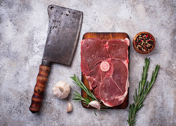 Mięso jagnięce z rozmarynem, przyprawy i tasak.  - Zdjęcie, obraz
