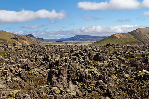 Исландский горный пейзаж. Лавовое поле и вулканические горы в Ландманналогарской геотермальной области. Одна из частей тропы Лаугавегура
 - Фото, изображение