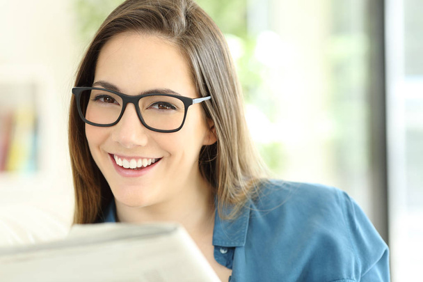 Nő a gazdaság egy újságot, néz rád szemüveg viselése - Fotó, kép