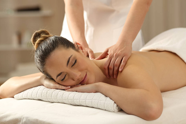 Relaxte dame ontvangen van een massage in een spa - Foto, afbeelding