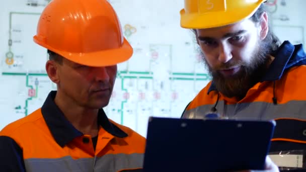 Dois engenheiros em capacetes de proteção trabalhando juntos na área de construção
 - Filmagem, Vídeo