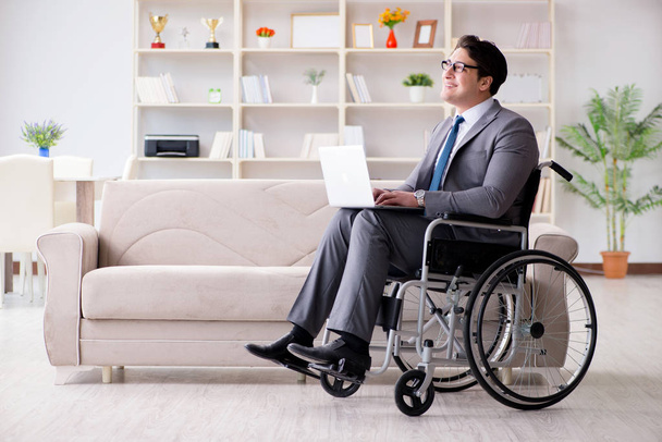 Юний бізнесмен на інвалідному візку працює вдома. - Фото, зображення