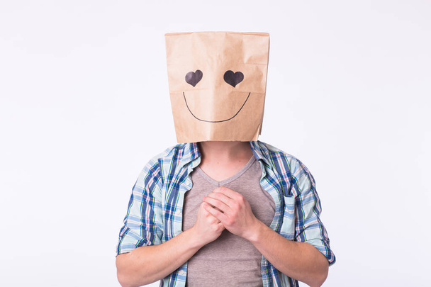Понятие любви, эмоций и отношений - Человек с картонной коробкой на голове с эмалированным лицом
. - Фото, изображение