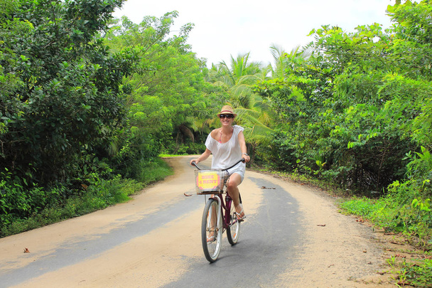Genç güzel turistik Panama Bocas del Toro adaların kum yollarında bisiklet sürmek. - Fotoğraf, Görsel