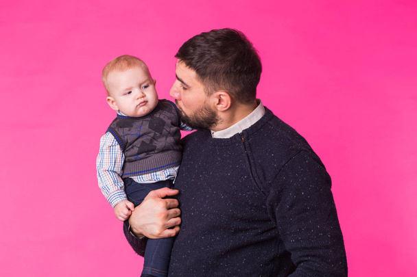 Ευτυχισμένος πορτρέτο του πατέρα και γιο σε ροζ φόντο. Στο studio - Φωτογραφία, εικόνα