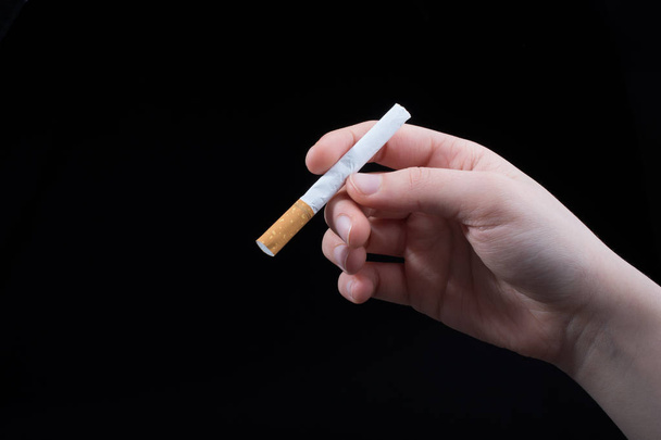 Kezében cigaretta-fekete háttér - Fotó, kép