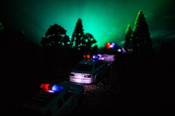 Carro da polícia perseguindo um carro à noite com fundo de nevoeiro. 911 Resposta de emergência carro da polícia acelerando para o local do crime. - Foto, Imagem