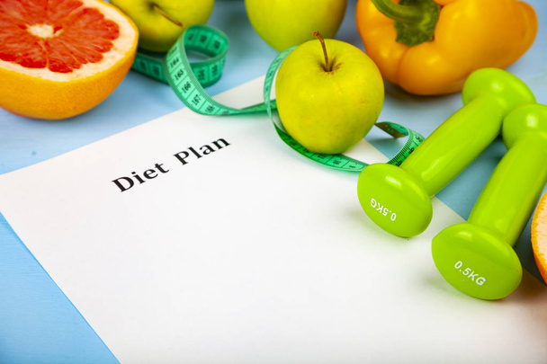 Alimentos y hoja de papel con un plan de dieta
 - Foto, imagen