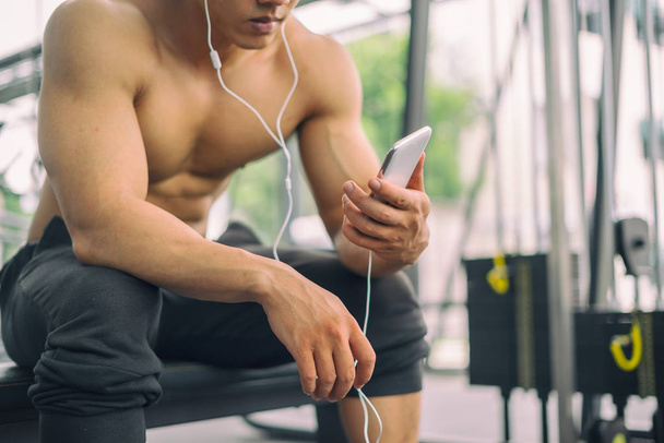 Fitness man relaxing seat listening to music after he exercises, fitness concept, sport concept - Zdjęcie, obraz