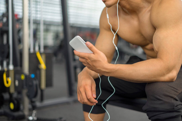 Fitness man relaxing seat listening to music after he exercises, fitness concept, sport concept - Foto, imagen