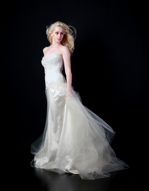 Ganzkörperporträt des Models im weißen Brautkleid, stehend posierend auf schwarzem Hintergrund. - Foto, Bild