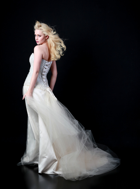 full length portrait of model wearing white bridal ball gown, standing pose on black background. - Photo, Image