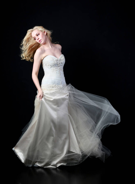 Pełna długość Portret model nosi białe Suknie ślubne suknia balowa, pozie stojącej na czarnym tle. - Zdjęcie, obraz