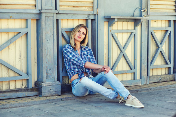 Stylish young woman in town . Girl dressed in jeans and a shirt . Casual wear - Fotó, kép