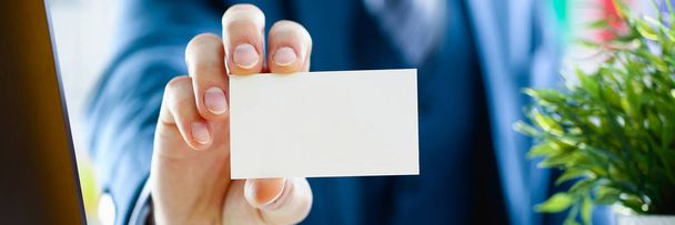 Brazo masculino en traje dar tarjeta de visita en blanco
 - Foto, Imagen