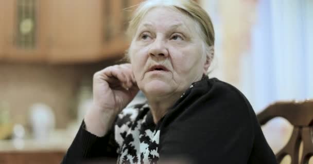 old grandmother tells the stories sitting at the table - Záběry, video