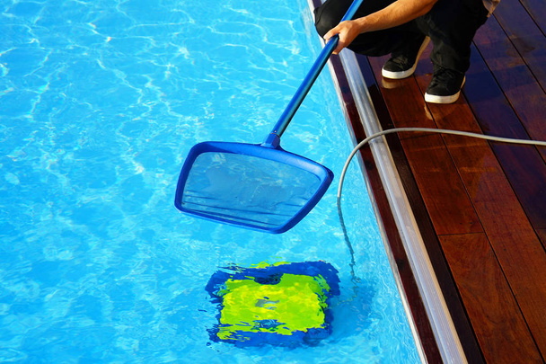 Персонал отеля убирает бассейн. Автоматические чистящие средства для бассейна
. - Фото, изображение