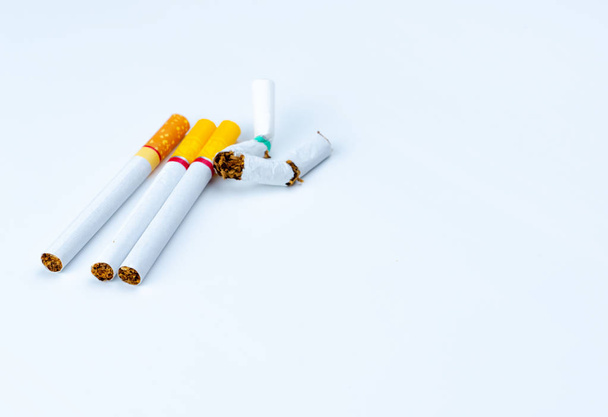 Σωρό από σπασμένα τσιγάρων που απομονώνονται σε λευκό φόντο με αντίγραφο χώρο για το κείμενο. Κλείστε το κάπνισμα έννοια. 31 Μαΐου: παγκόσμια ημέρα δεν καπνού. Διακοπή καπνίσματος. Σταματήστε το κάπνισμα τσιγάρων έννοια.  - Φωτογραφία, εικόνα