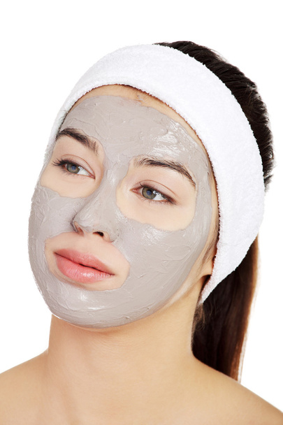 Beautiful woman with clay facial mask - Фото, изображение