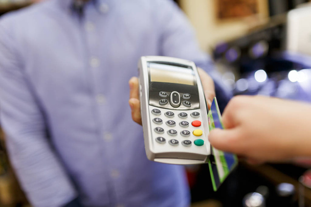 Immagine del venditore con terminale in mano e compratore con carta di credito
. - Foto, immagini