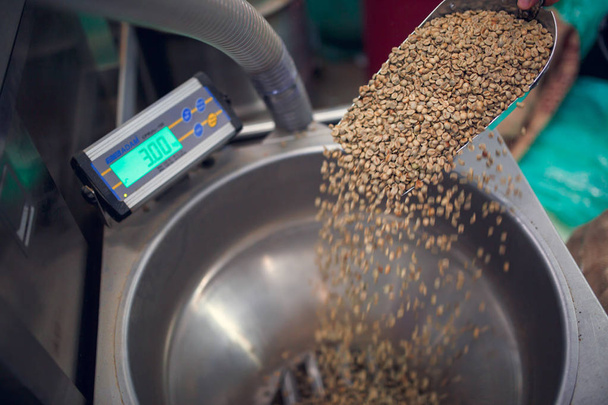 Image of scoop with non-roasted coffee beans, industrial scales - Photo, Image