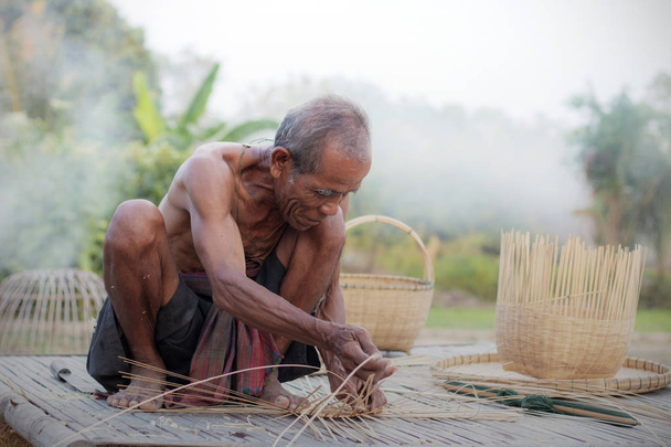 Viejo está tejiendo en el campo de Tailandia
. - Foto, imagen