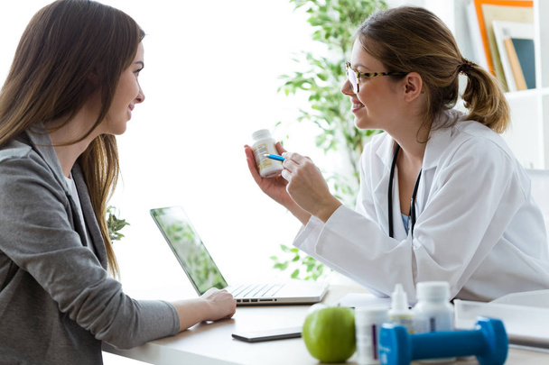 Female dietician prescribing nutritional supplement for patient in the consultation. - Photo, image