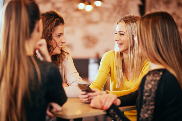 Жінки друзі п'ють вино і спілкуються, сидячи в барі
. - Фото, зображення