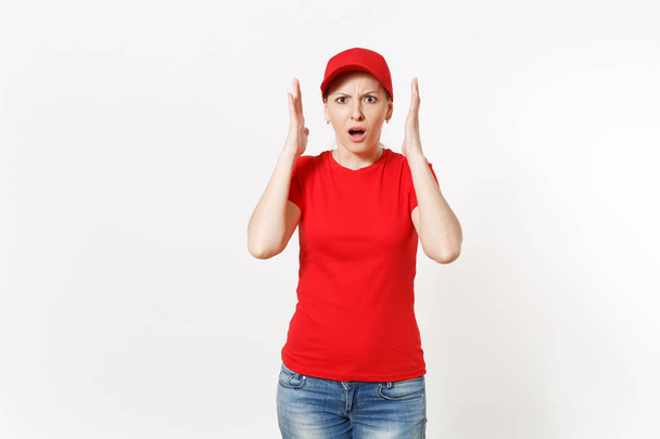 Παράδοση γυναίκα με κόκκινη στολή που απομονώνονται σε λευκό φόντο. Επαγγελματική σοκαρισμένος γυναίκα με καπέλο, μπλουζάκι, τζιν εργάζεται ως κούριερ ή αντιπρόσωπο, κρατώντας τα χέρια κοντά στο πρόσωπό χειρονομία. Χώρο αντίγραφο, διαφήμιση. - Φωτογραφία, εικόνα