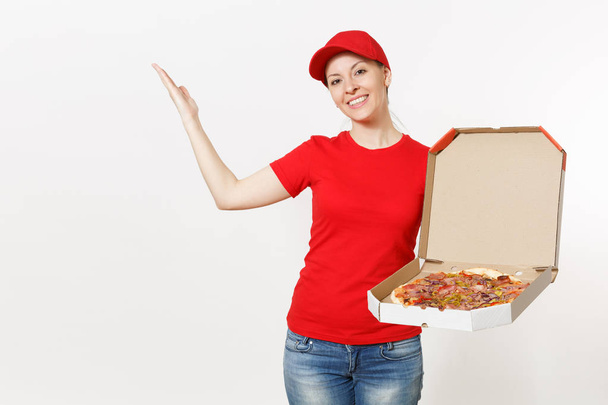 Dodávky žena v červených uniformách izolovaných na bílém pozadí. Pěkná žena v čepici, triko, džíny, pracoval jako kurýr nebo prodejce hospodářství italskou pizzu v lepenkové flatbox. Kopírovat prostor pro reklamu. - Fotografie, Obrázek