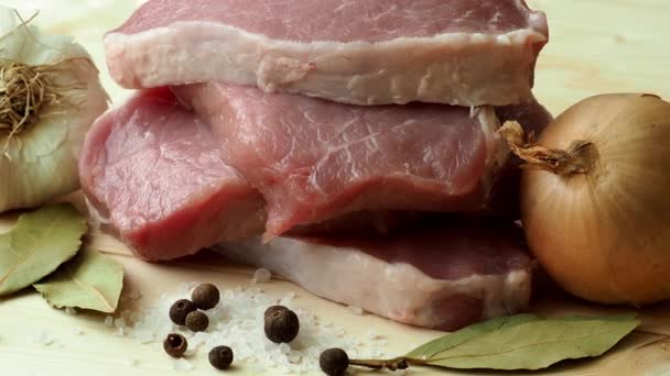 свежая свинина с ингредиентами для приготовления пищи на деревянной доске
 - Кадры, видео