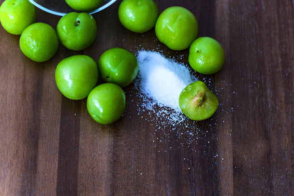 El fruto de ciruelas verdes con sal, fondo de madera
 - Foto, Imagen