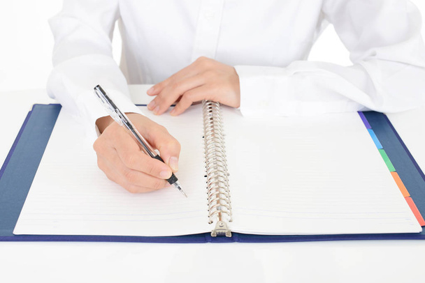 Mano femenina con bolígrafo escrito en cuaderno - Foto, Imagen