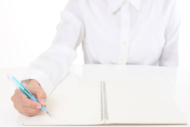 Mano femenina con bolígrafo escrito en cuaderno - Foto, Imagen