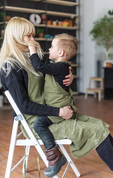 Mom and son are sitting in a chair in in creative studio. Mothers Day.  - Valokuva, kuva